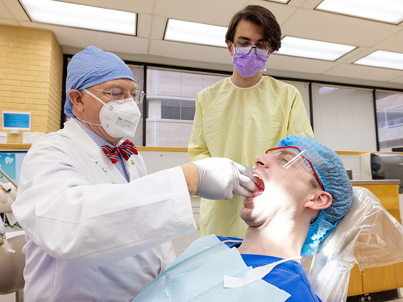 Third-year dental student Gunner Rhoden observes as Dr. William Boteler shows him how to screen patients for sleep apnea. Rhoden's classmate, Andrew Spearman, acts as the patient being screened.